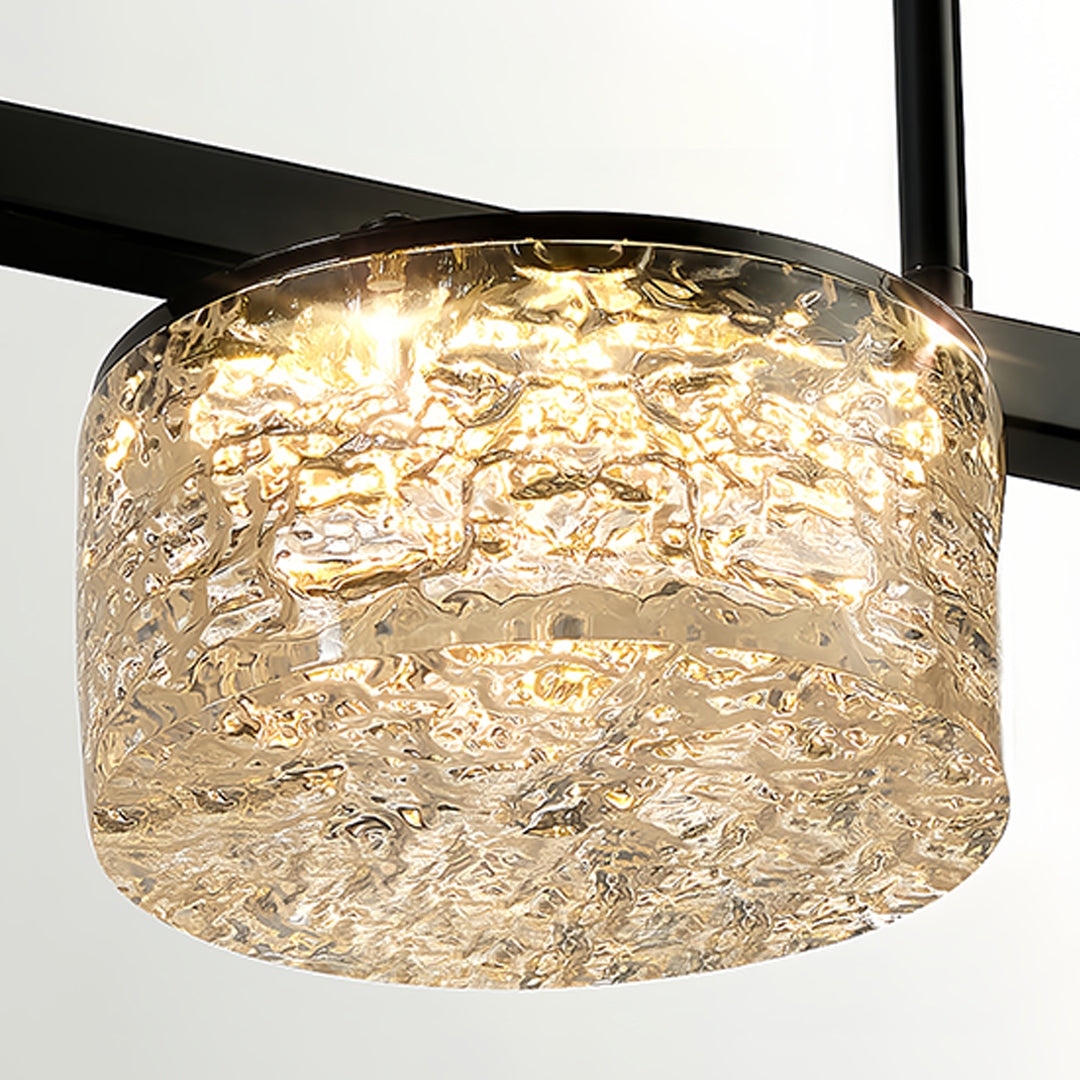 Close-up detail of LED linear pendant light showing textured crystal glass shade and warm illumination