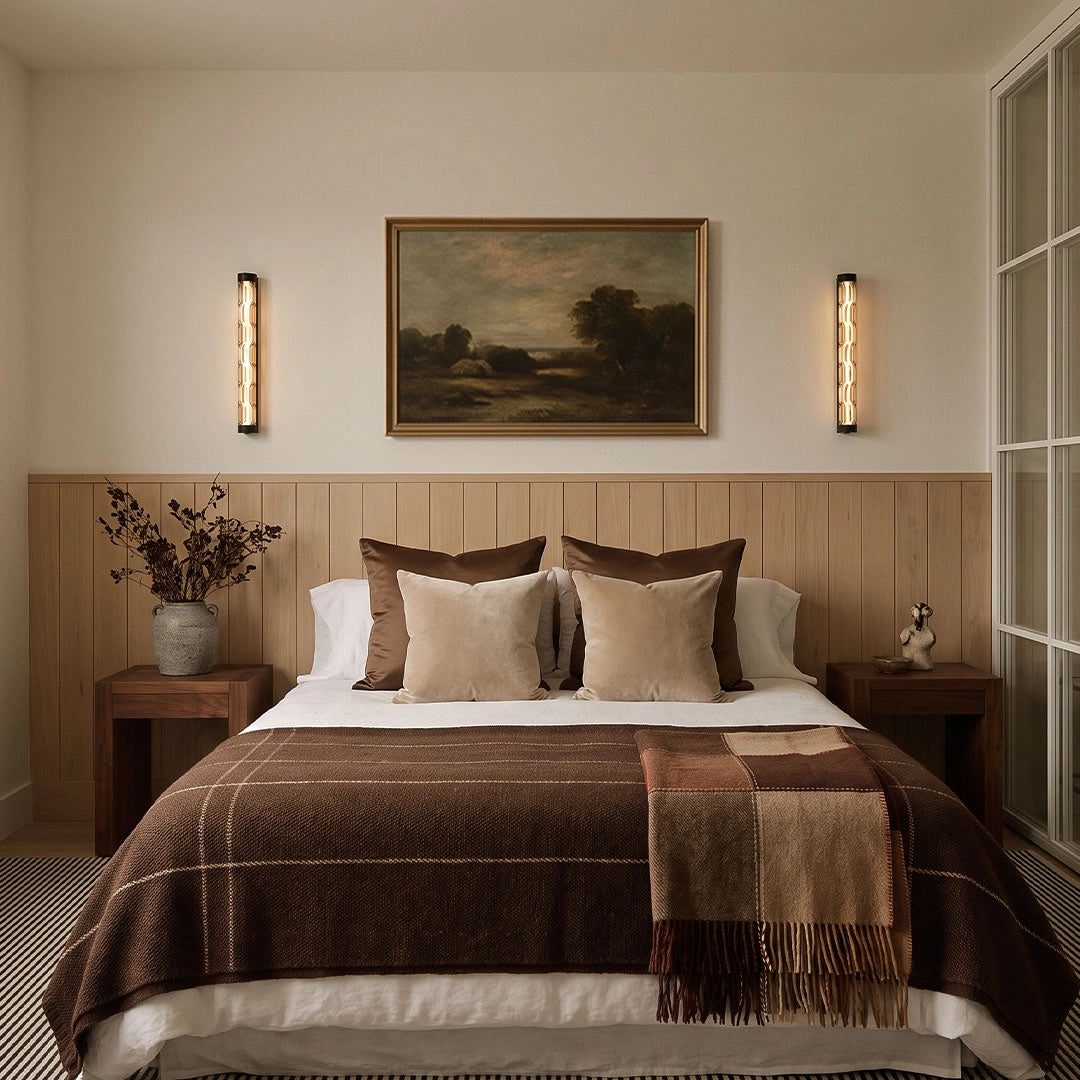 LED linear wall lights installed on both sides of a bed in a warm neutral bedroom.