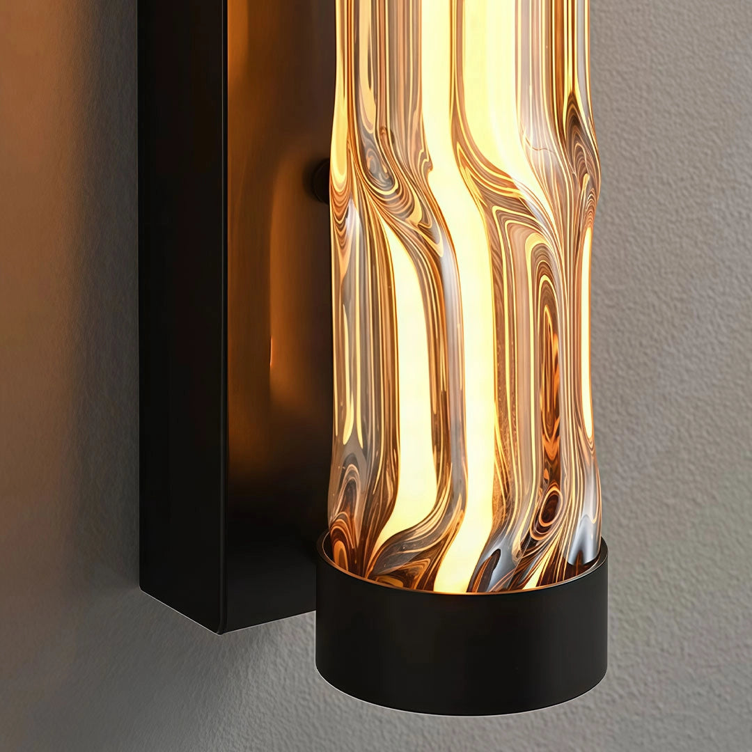 Close-up of an LED linear wall light with a black frame and textured amber glass shade.