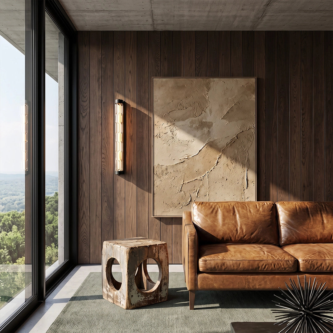 LED linear wall light mounted on a dark wood wall beside a brown leather sofa.