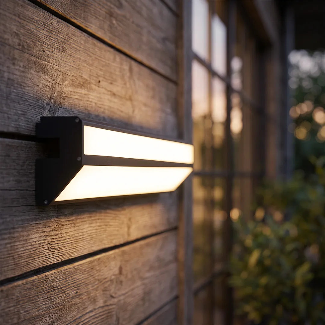 LED linear wall sconce mounted on a wood exterior wall in a close-up outdoor setting.