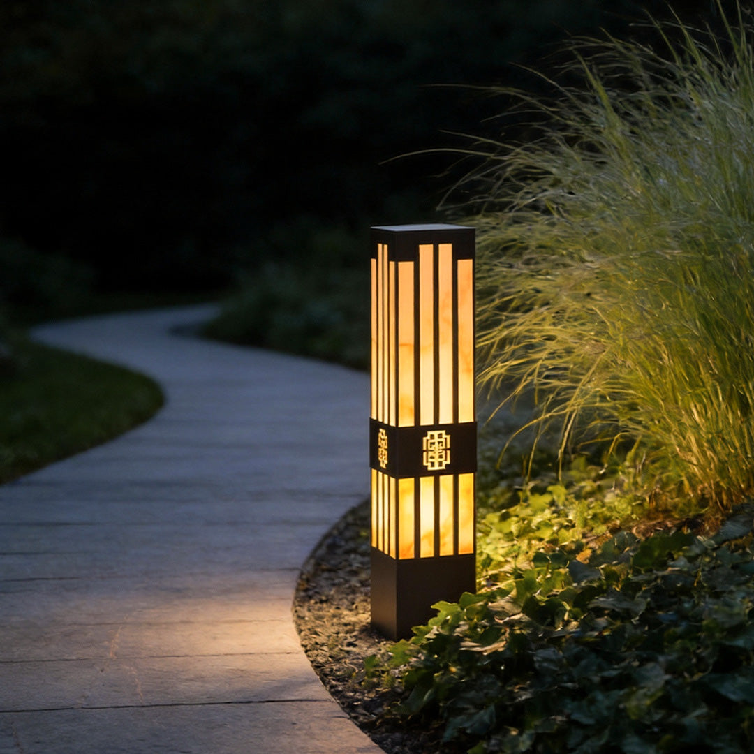 LED marble bollard light illuminating a garden pathway with a warm, elegant glow.