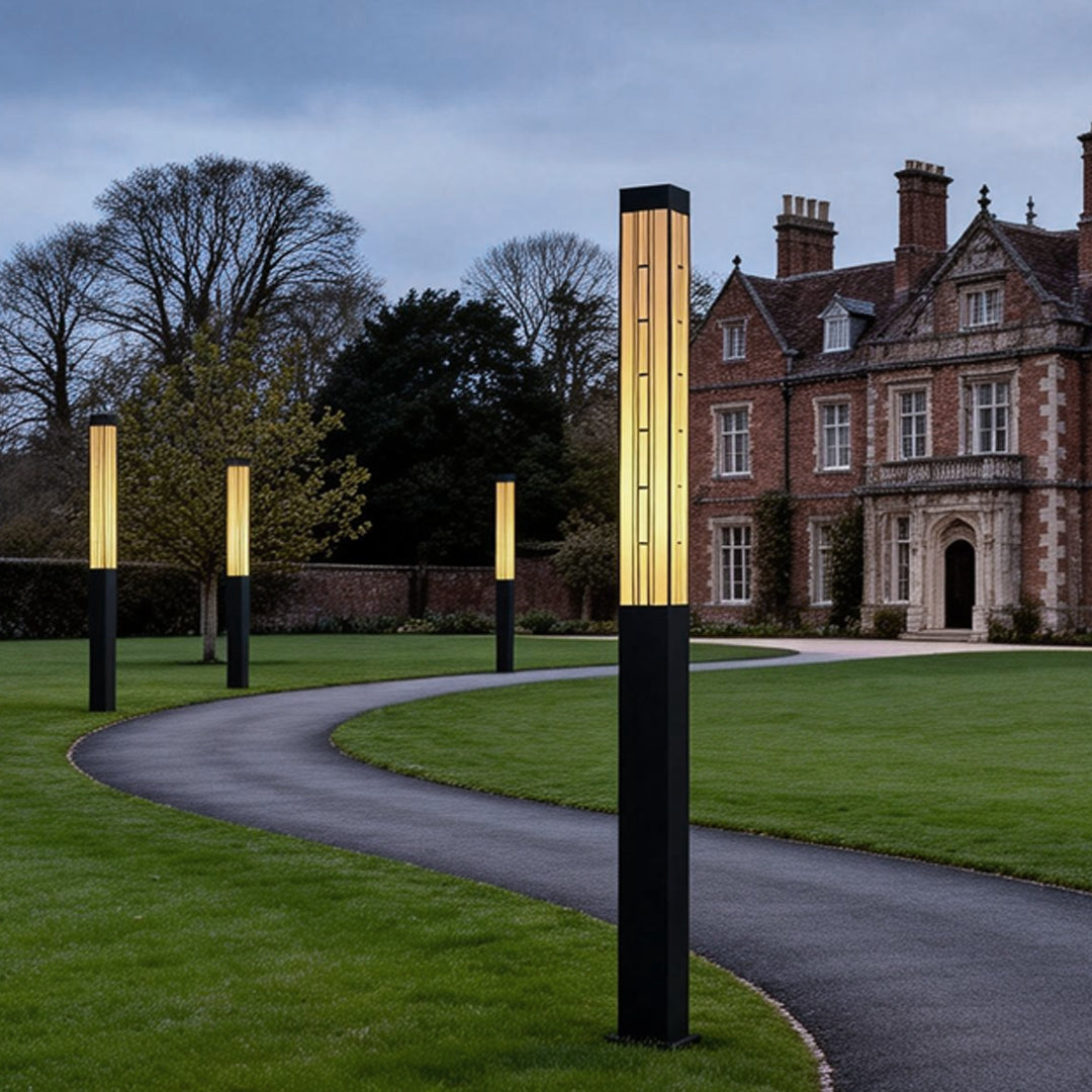 LED marble bollard light providing warm illumination along a curved driveway.