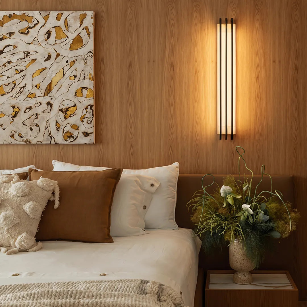 LED modern wall lights mounted above a bedside table in a warm wood-paneled bedroom.
