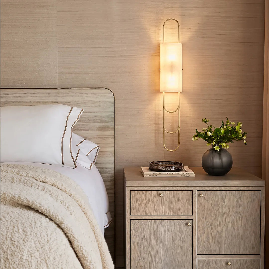 LED modern wall sconce mounted beside a bedside cabinet with a frosted shade and warm ambient glow.