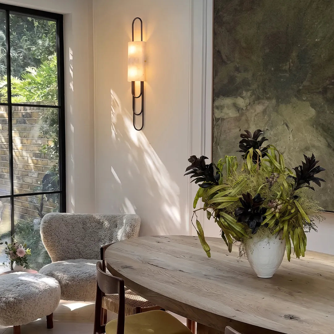 LED modern wall sconce illuminating a dining area with a minimalist vertical frame and soft warm light.