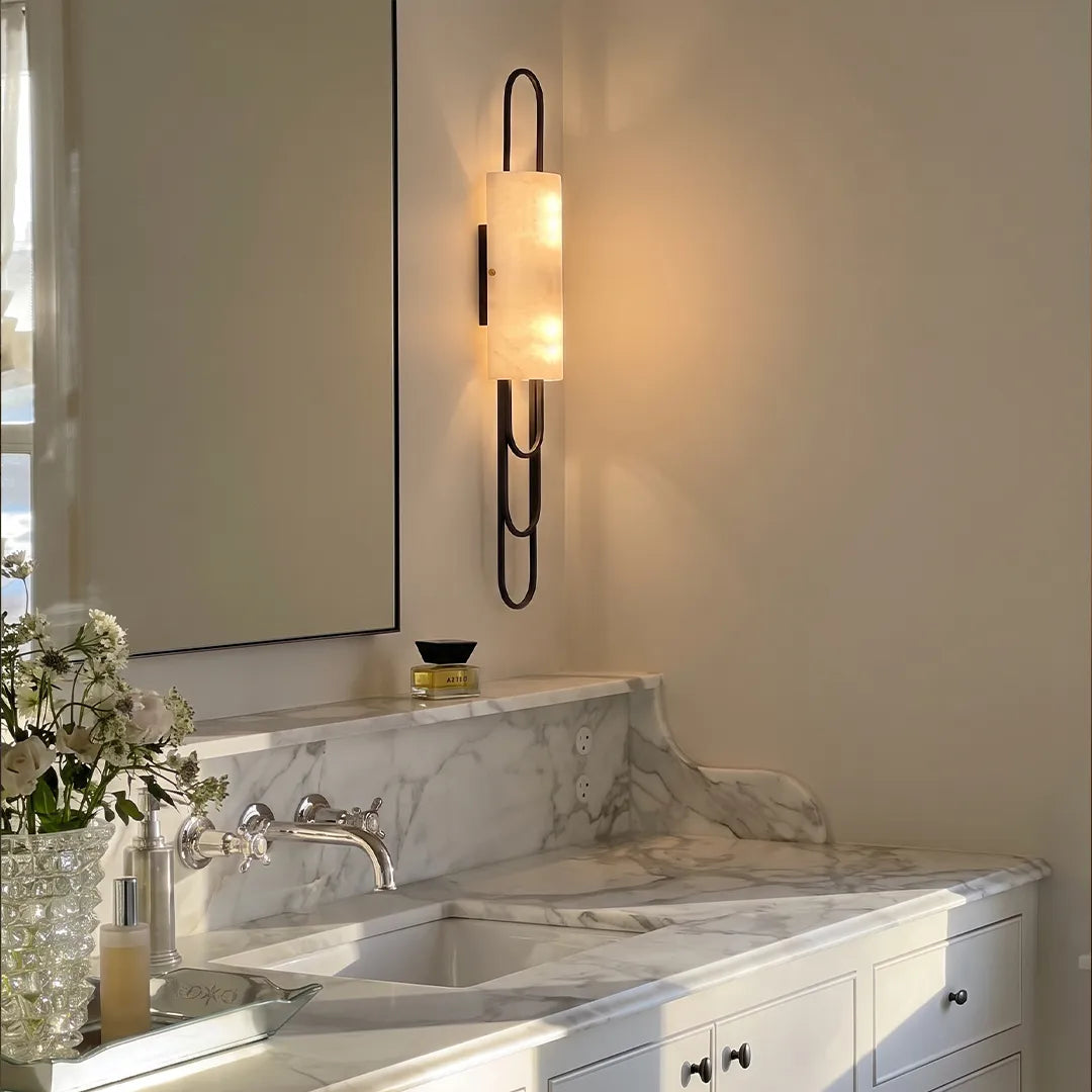 LED modern wall sconce mounted above a marble vanity with a frosted shade and black metal frame.