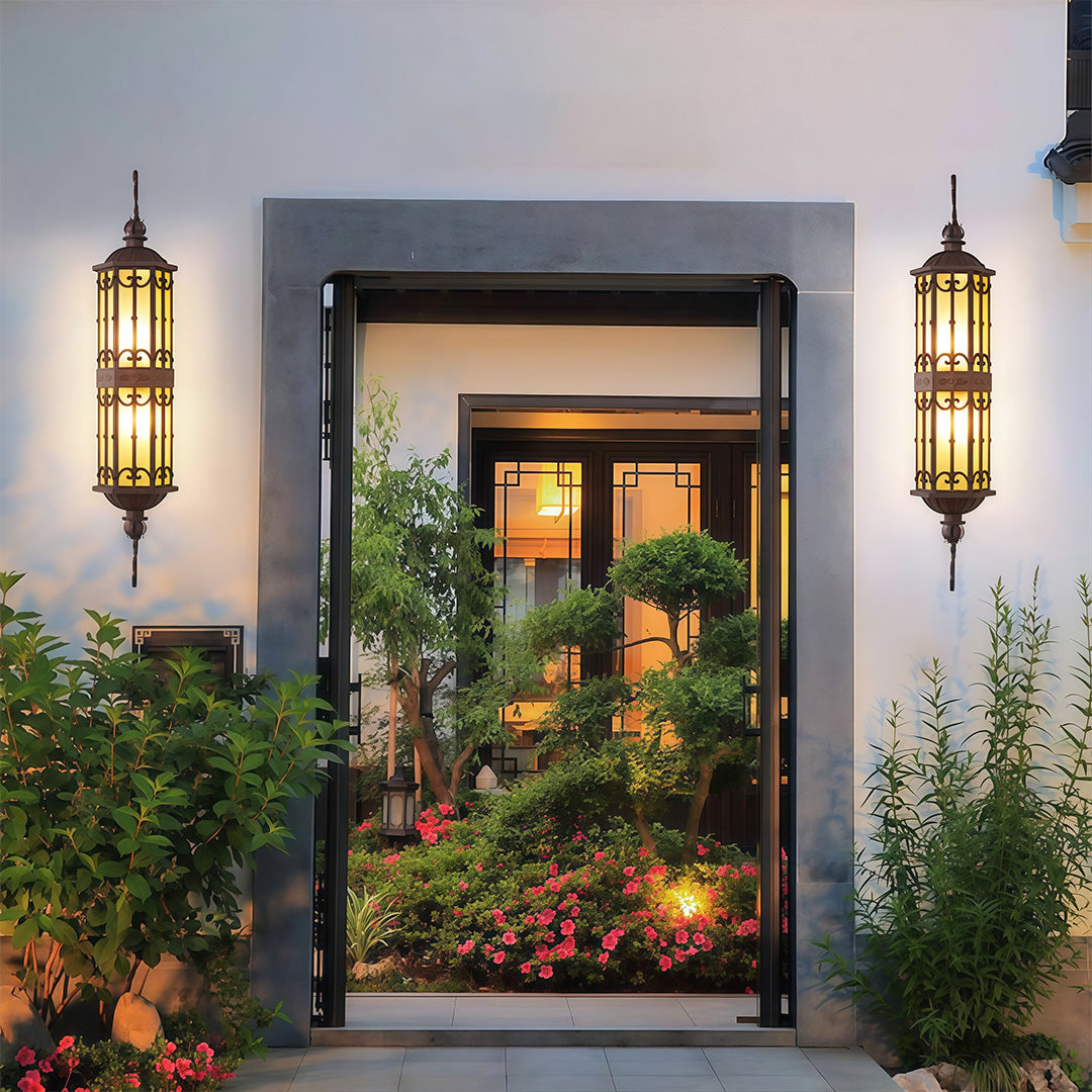 LED outdoor light fixture with intricate scrollwork, illuminating the doorway of a home.