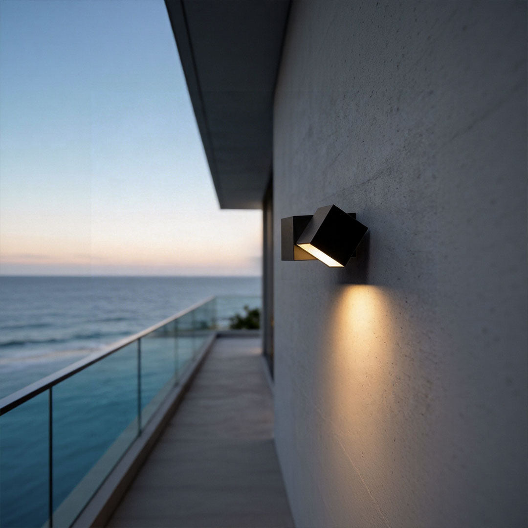 LED outdoor lighting wall mount with a contemporary geometric design, providing warm illumination near a balcony.