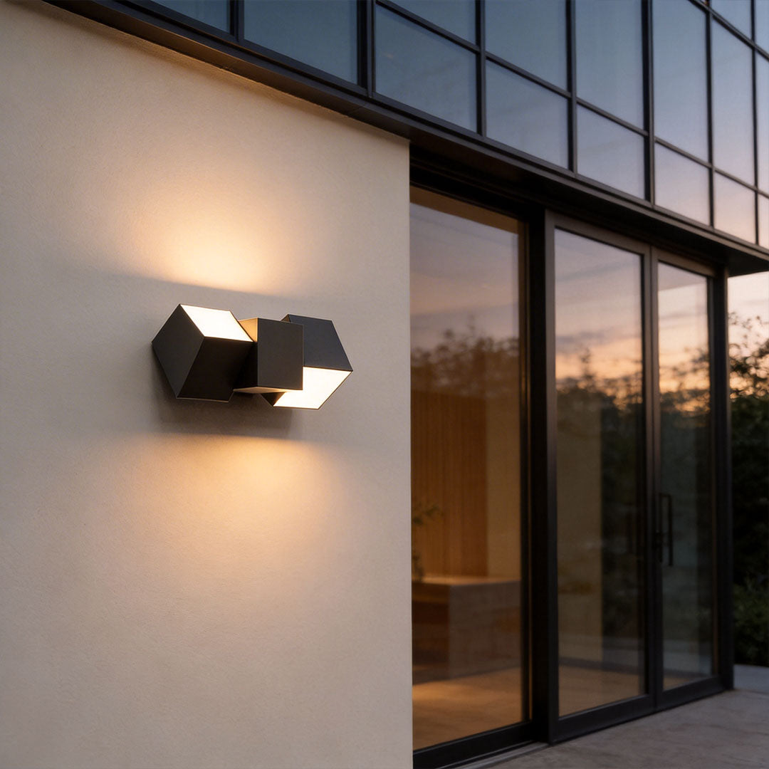 LED outdoor lighting wall mount with a modern geometric design, mounted on a white wall.