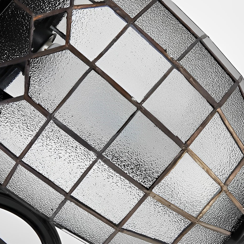 Close-up of LED outdoor sconce glass shade showing textured grid pattern.