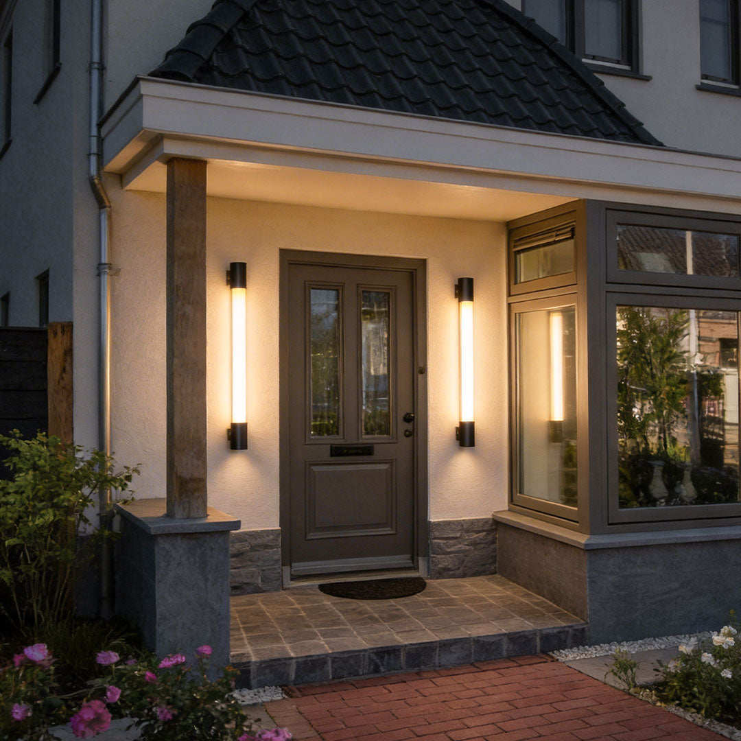 LED outdoor sconce with a modern design, mounted beside a front door, providing warm illumination.