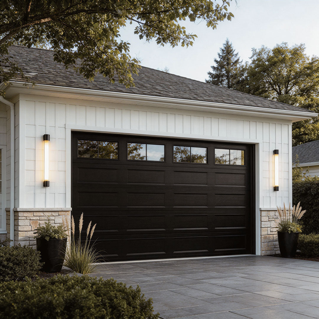 LED outdoor sconce with a sleek design, illuminating a garage exterior at dusk.