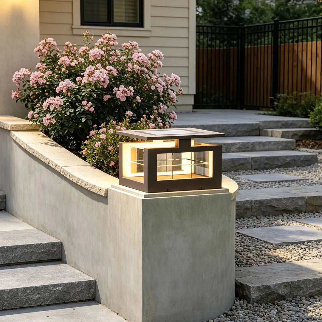 LED pillar lights mounted on a concrete post beside outdoor steps, casting a warm glow over a modern garden entrance.