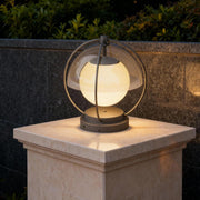 Modern spherical led pillar lights outdoor mounted on stone column with soft warm glow enhancing contemporary garden landscape