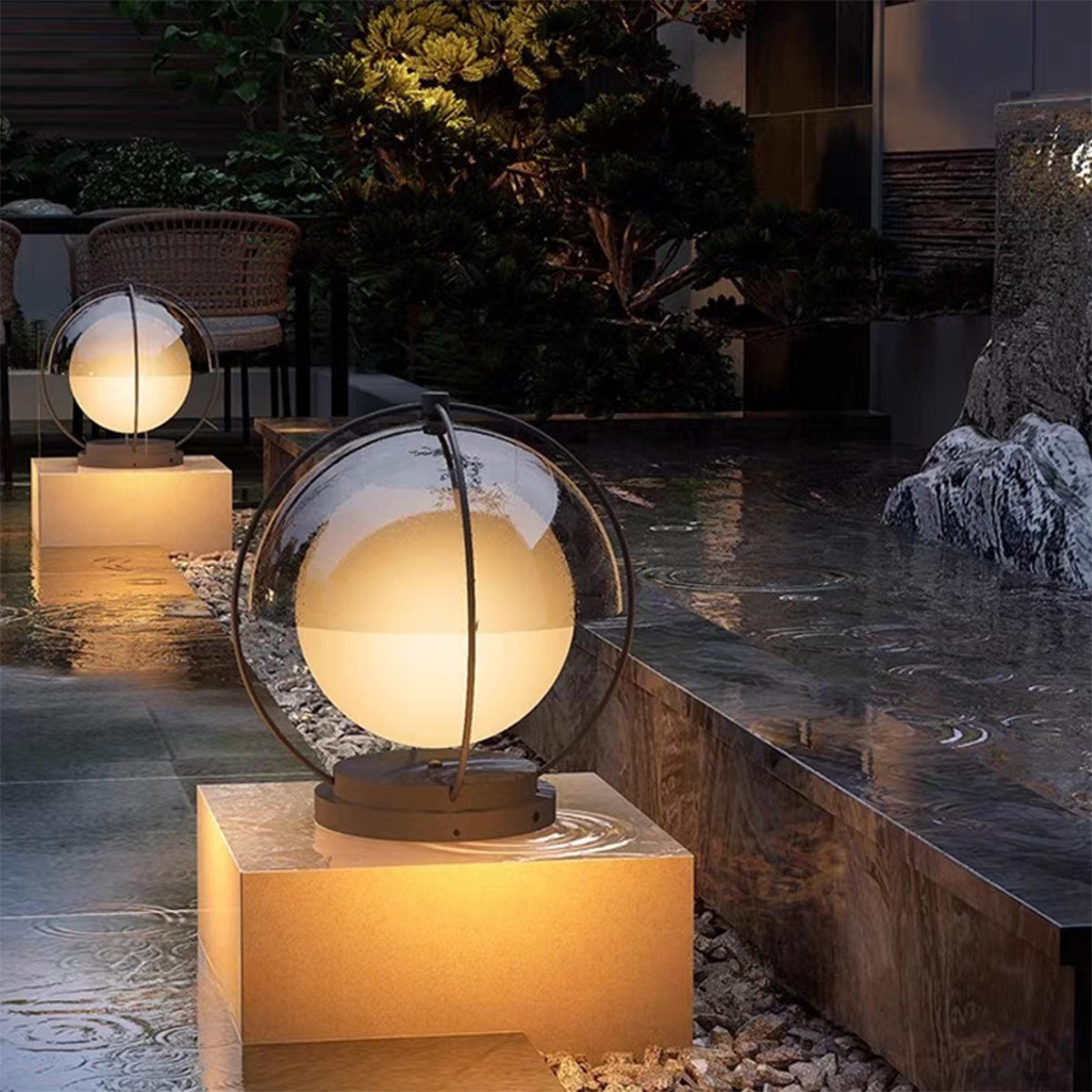 Led pillar lights outdoor beside water feature with soft diffused glow reflecting on stone surfaces