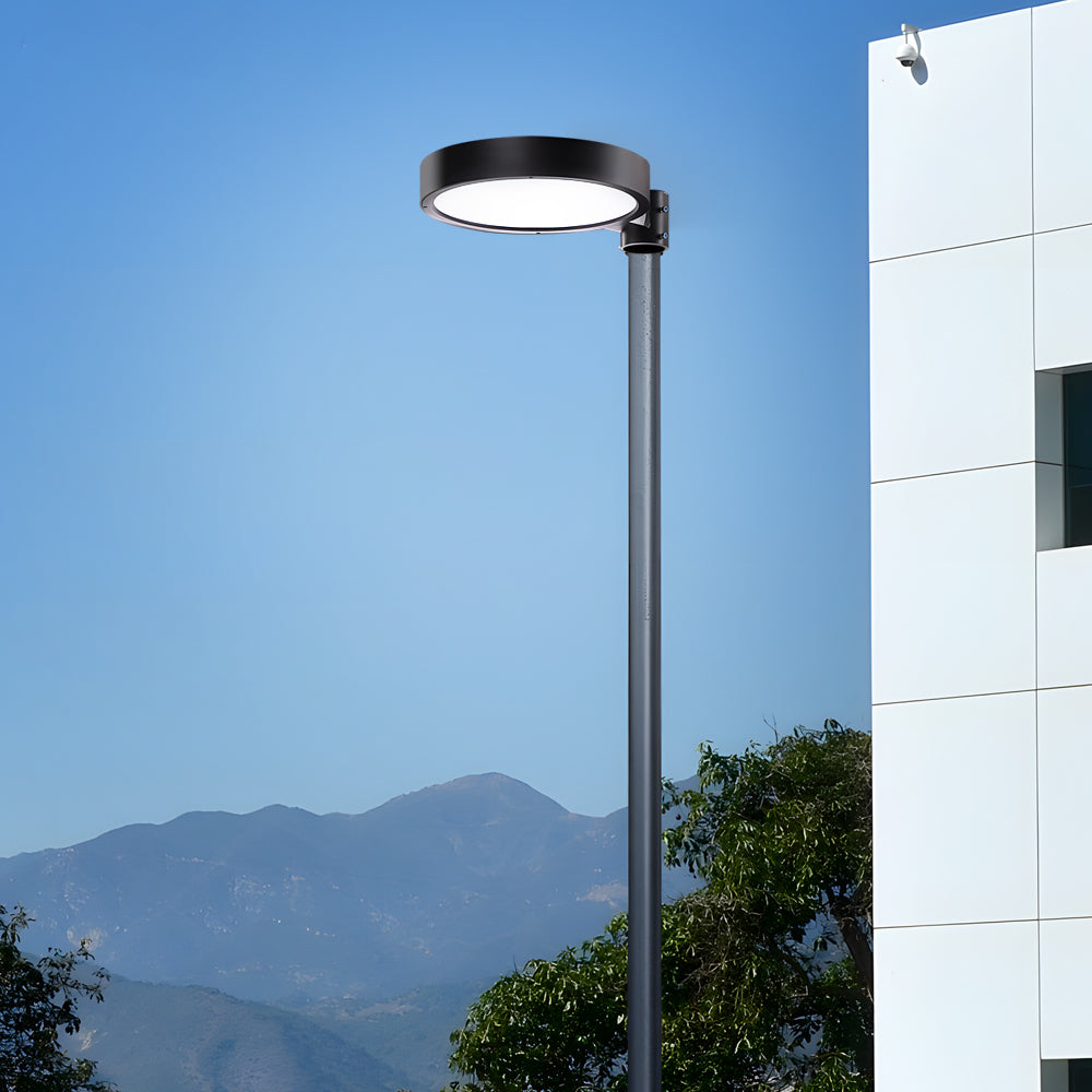 LED pole light with a modern design, mounted against a scenic mountain backdrop.