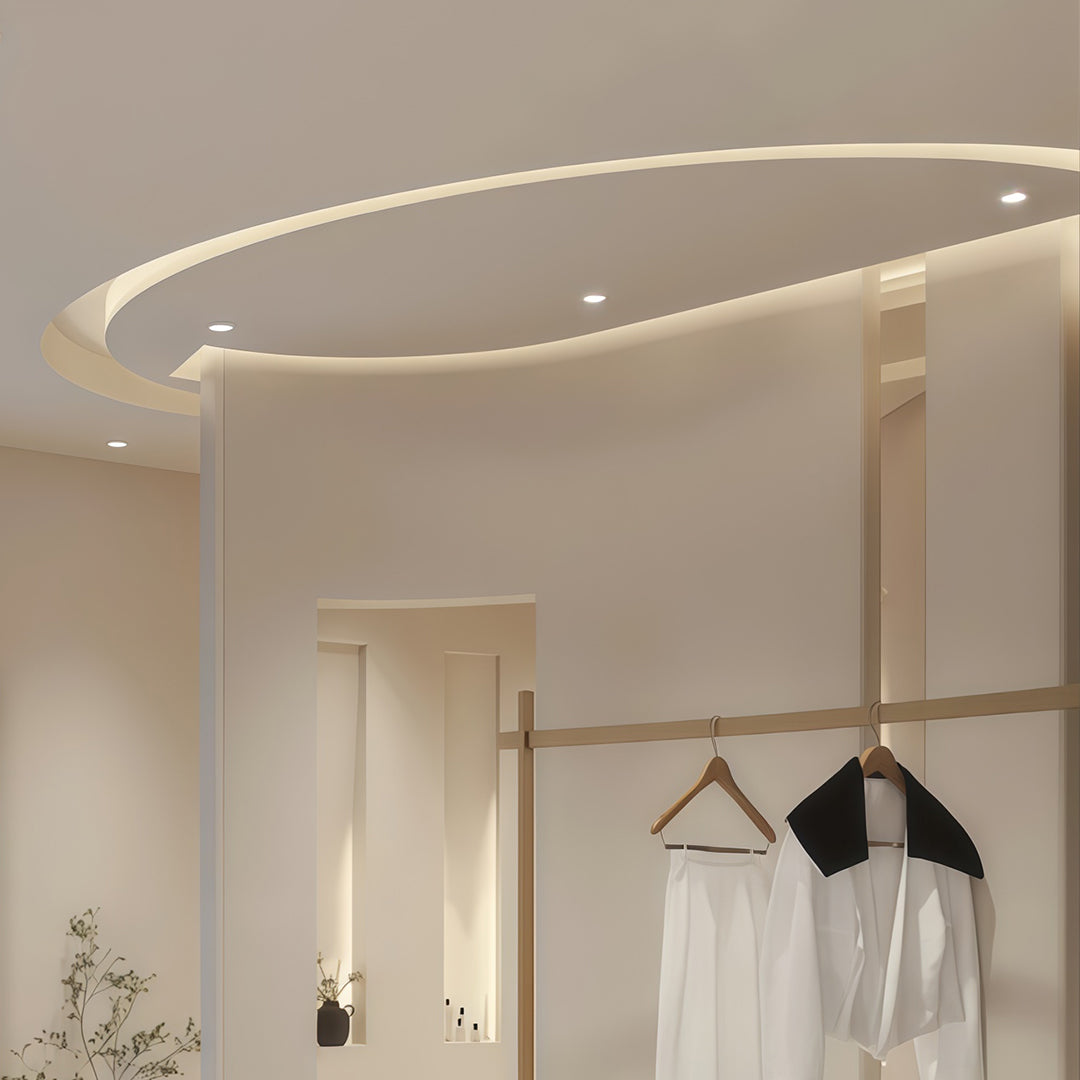 LED recessed downlights and circular pendant creating layered lighting in upscale clothing store
