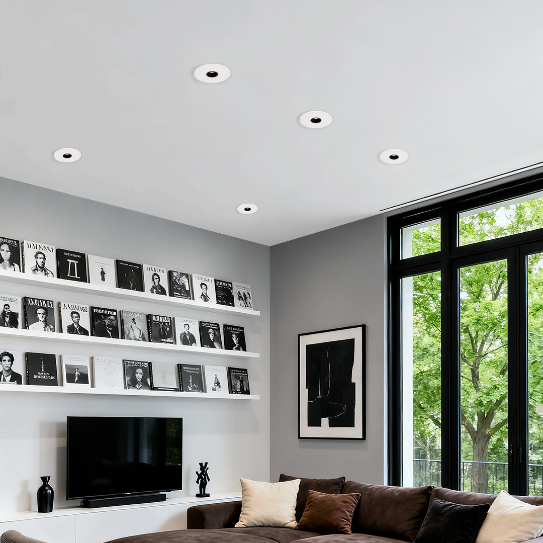 LED recessed spotlights providing task lighting in modern living room with built-in shelving and large windows