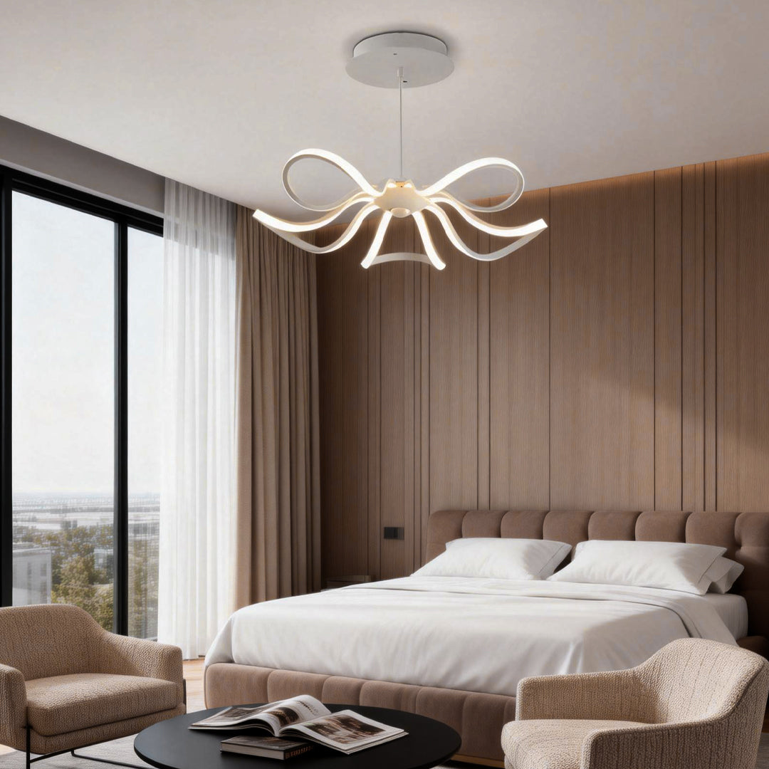 LED ribbon chandelier providing warm illumination above a dining table in a cozy bedroom setting.