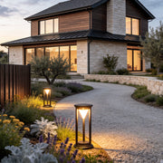 LED solar bollard lights illuminating a modern driveway with warm, ambient glow.