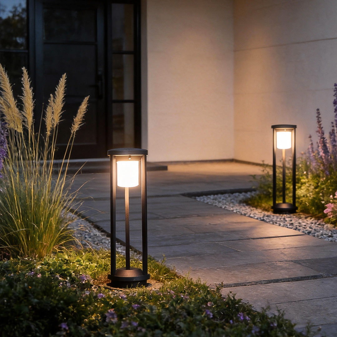LED solar bollard lights providing soft illumination along a garden pathway.