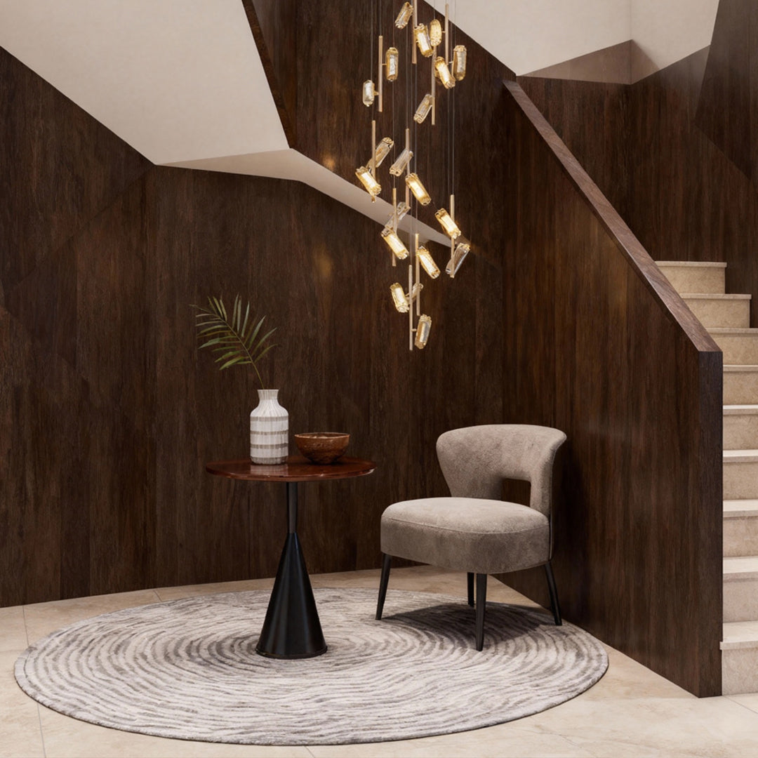Led staircase chandelier creating sculptural lighting effect in luxurious entryway with dark wood paneling