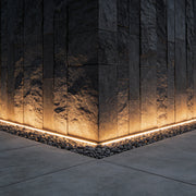 LED strip lights on wall providing ambient illumination along a stone pathway.