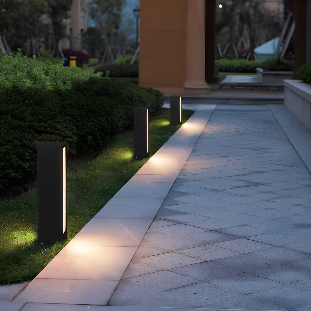 Outdoor pathway illuminated by evenly spaced led wall light outdoor posts casting warm downward light.