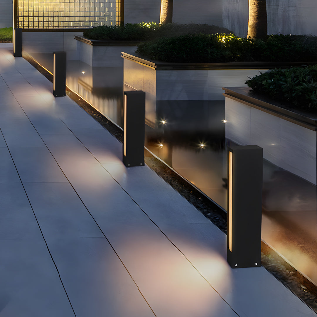 Modern garden walkway featuring short bollard-style led wall light outdoor fixtures providing ambient illumination.