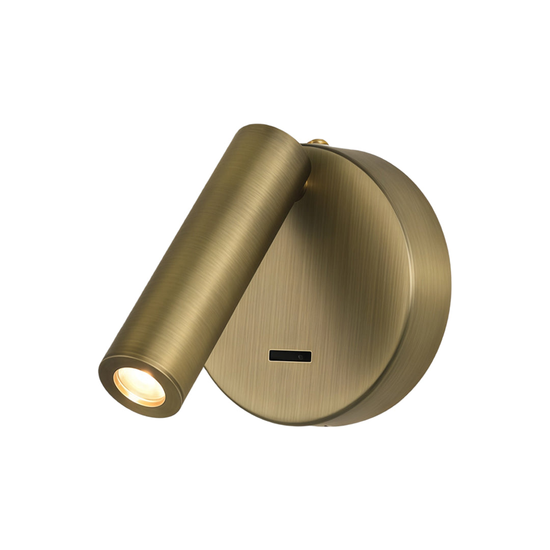 Close-up detail of brass LED wall reading light with brushed finish and cylindrical spotlight head.