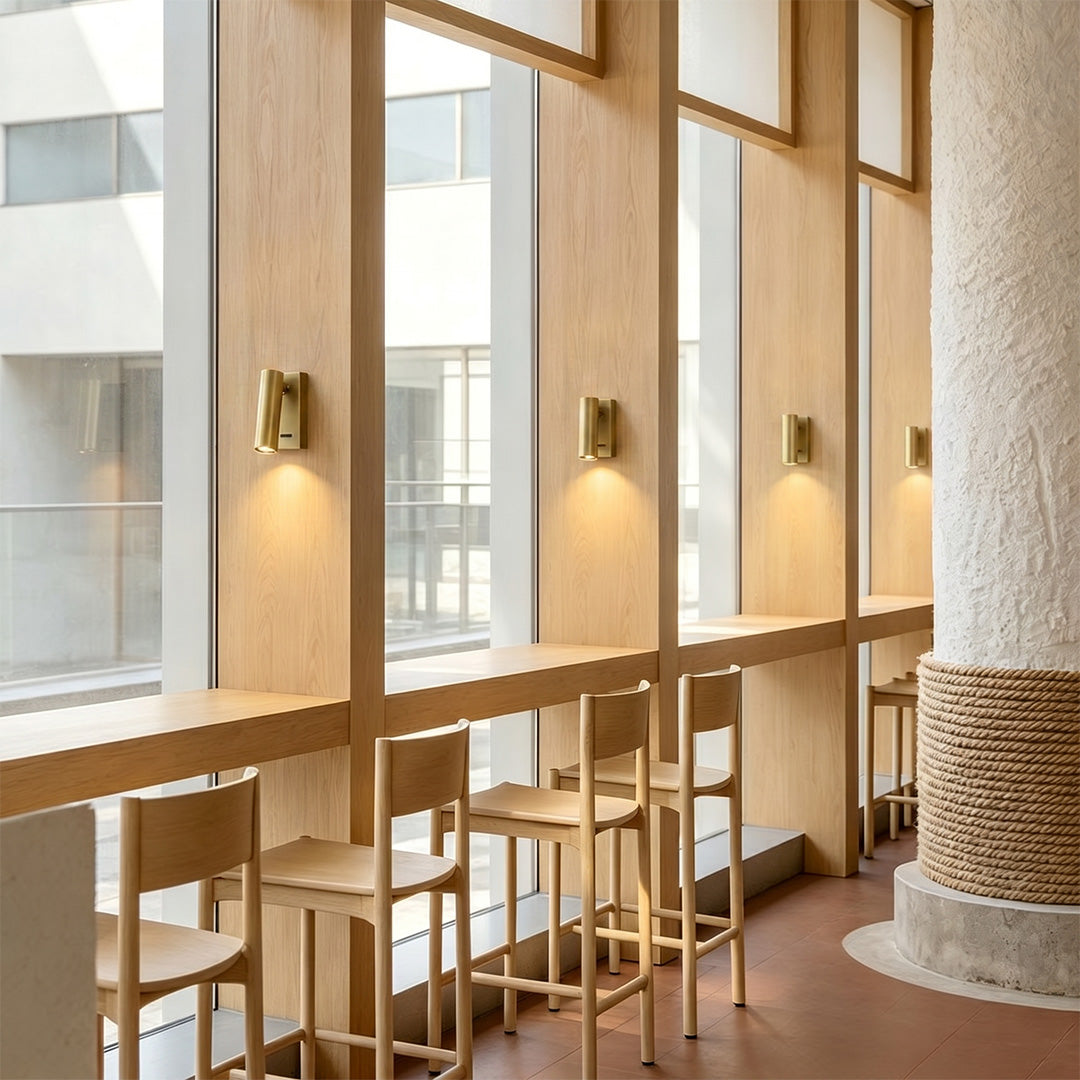 Elegant LED wall reading light illuminating modern cafe seating area with warm ambient glow.