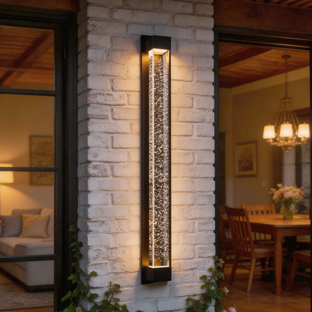 LED wall sconce outdoor on brick wall, tall linear light fixture with sparkling bubble glass effect.