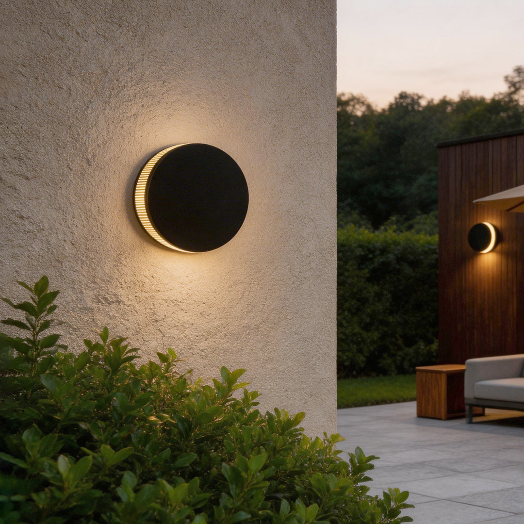 LED wall sconce outdoor circular design on exterior wall, warm backlit glow with minimalist modern style.