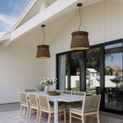 LED wall sconce outdoor woven light pendant hanging over patio dining table, natural rattan shade outdoor setting.
