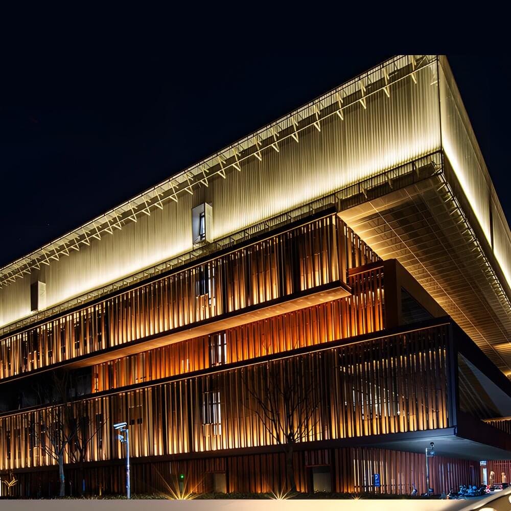 LED wall washer light illuminating the roofline of a contemporary building with warm white light.