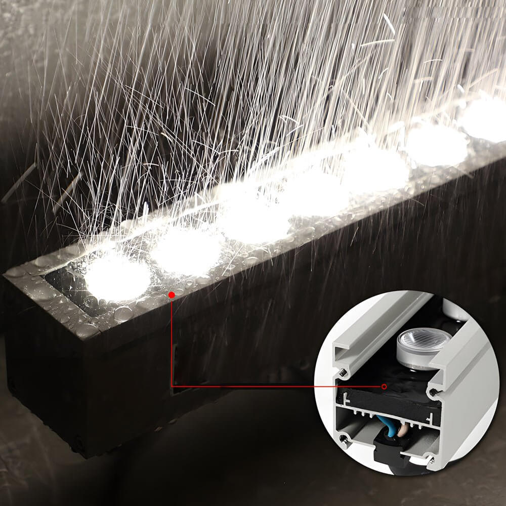 LED wall washer light installed near a water feature, creating dynamic lighting effects for outdoor spaces.