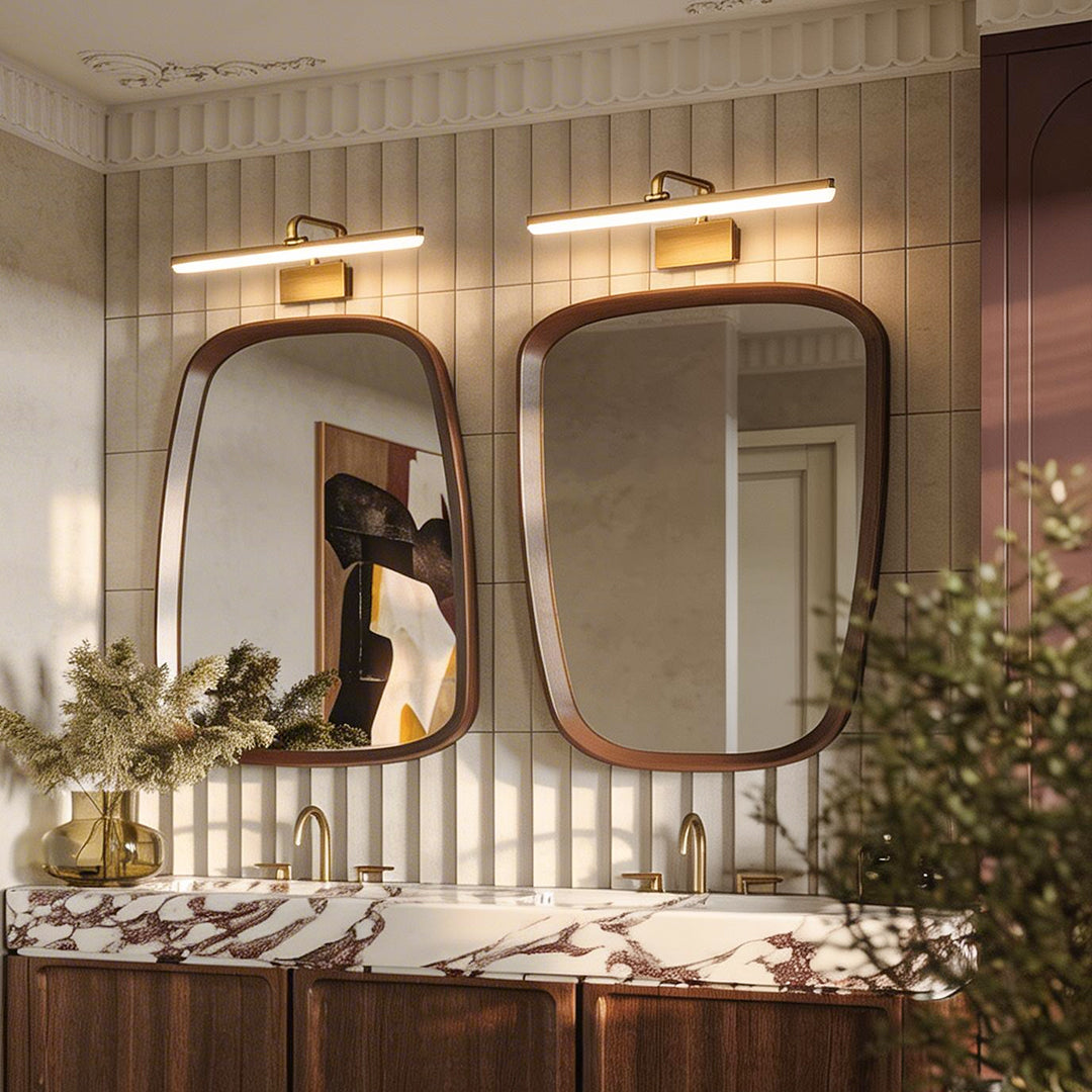 Light bar vanity with a sleek gold design, illuminating a modern bathroom mirror setup.