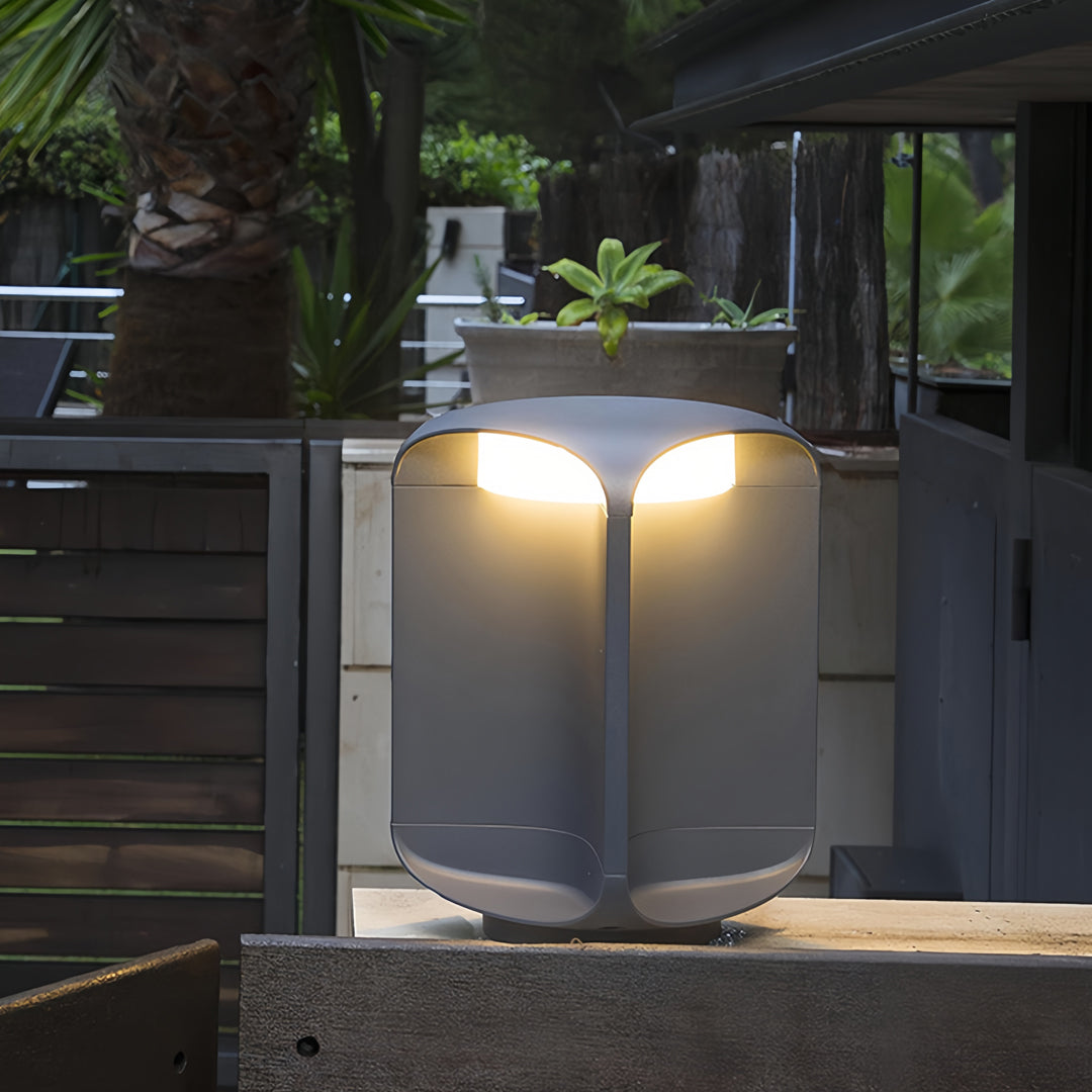 Dual light bollards providing warm illumination for a contemporary backyard patio.
