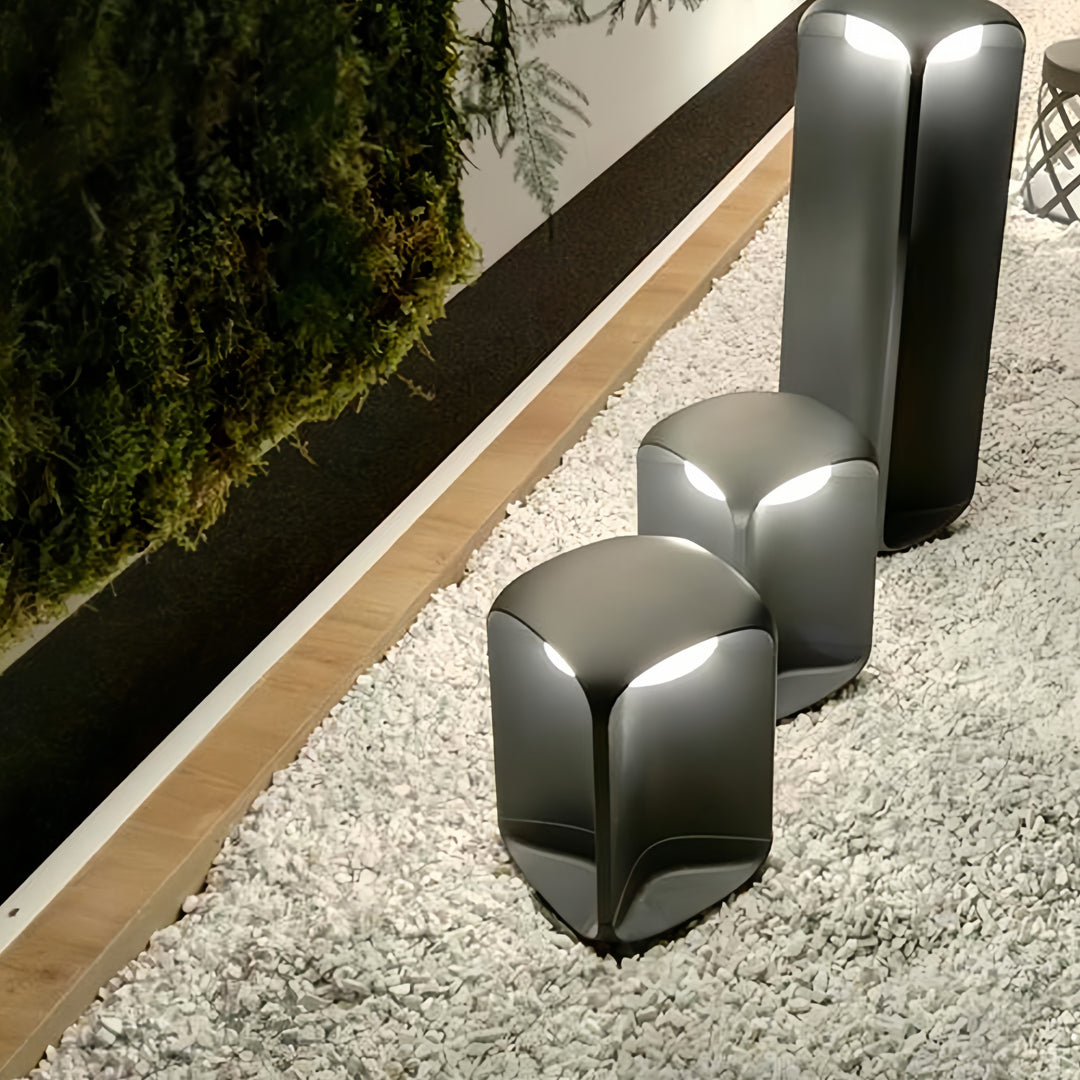 Cluster of light bollards arranged along a landscaped walkway with gravel ground cover.