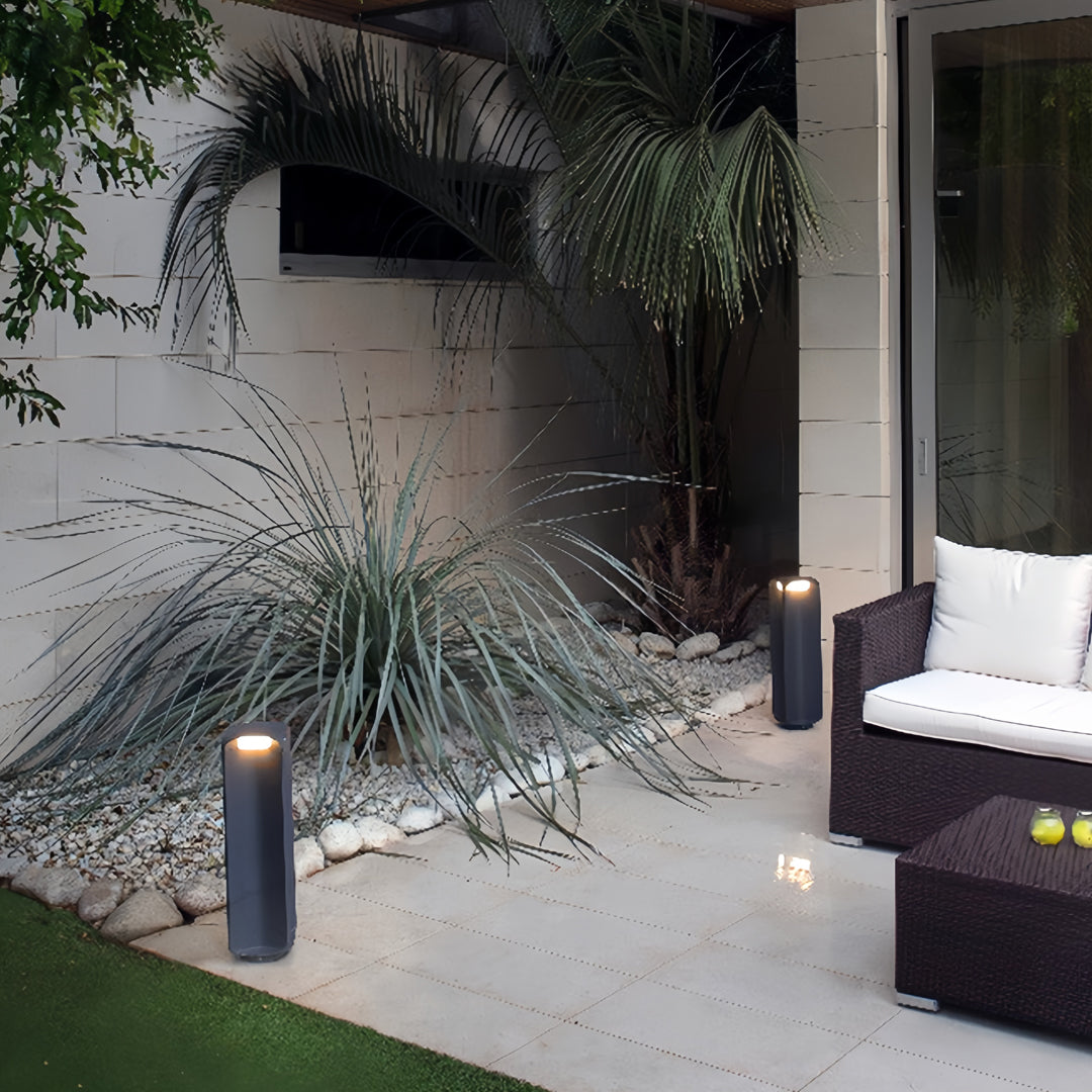 Light bollard installed beside modern outdoor stairs, adding soft pathway illumination.