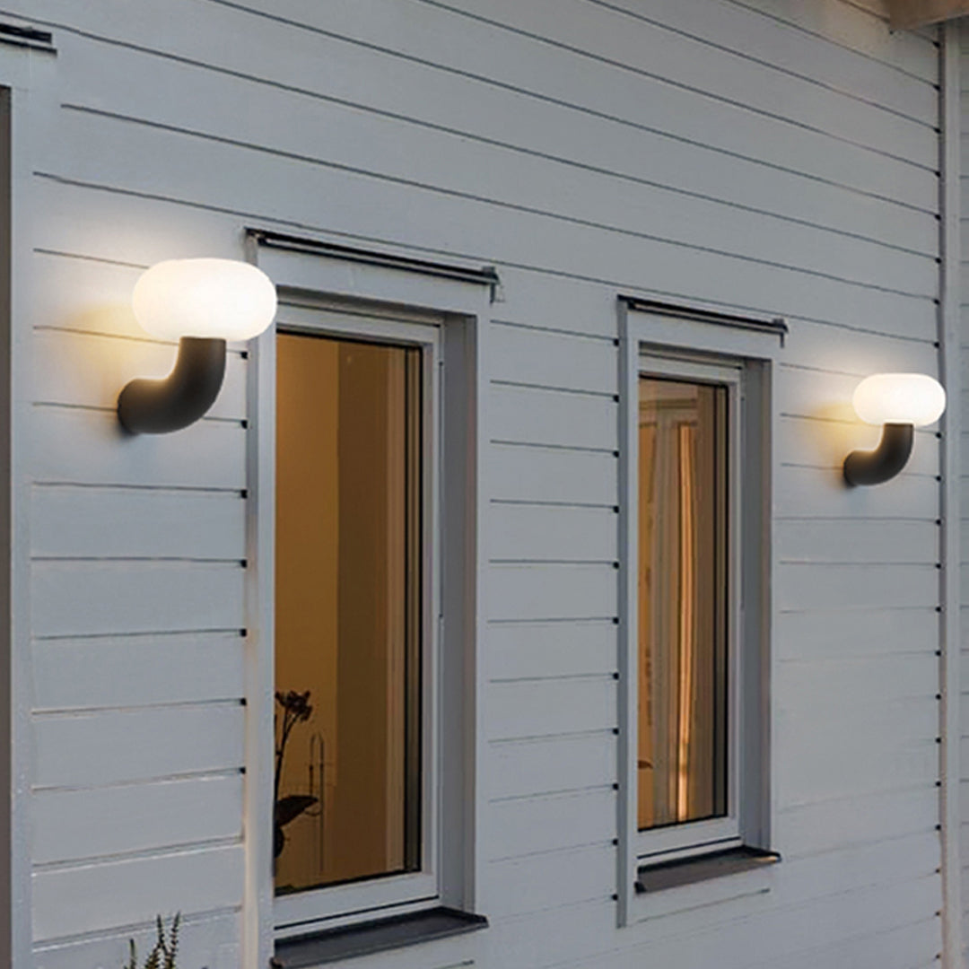 Pair of modern light outdoor wall sconce fixtures installed on a white exterior façade with soft ambient glow.