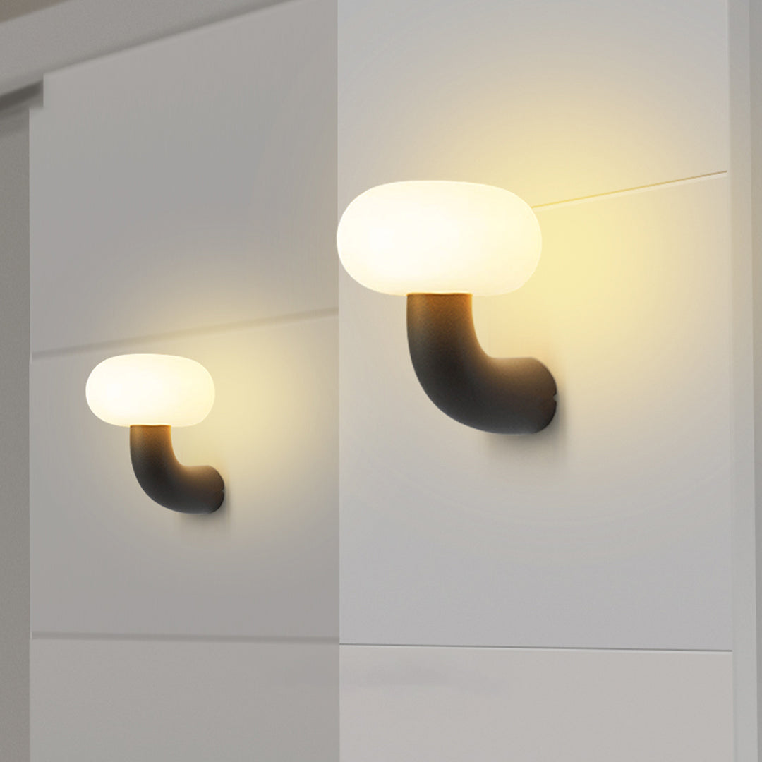 Twin modern light outdoor wall sconce fixtures illuminating a smooth white outdoor wall with warm diffused light.