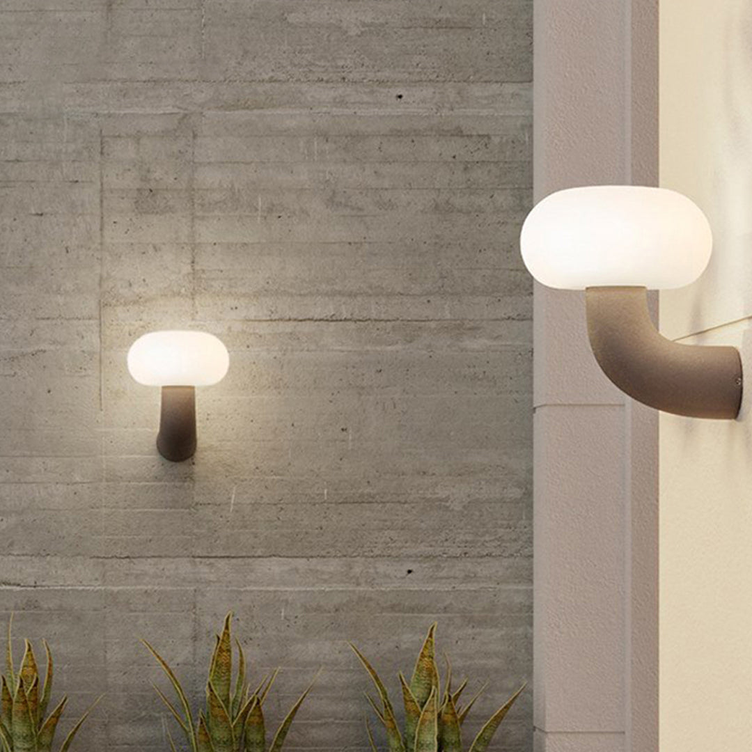Stylish light outdoor wall sconce mounted on a concrete exterior wall providing soft downward glow.