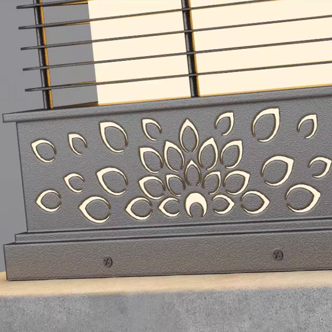 Light pillar for home with a floral cut-out design, casting a soft light on a stone base.