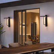 Light sconces outdoor illuminating a patio area with warm evening light and modern architectural styling.