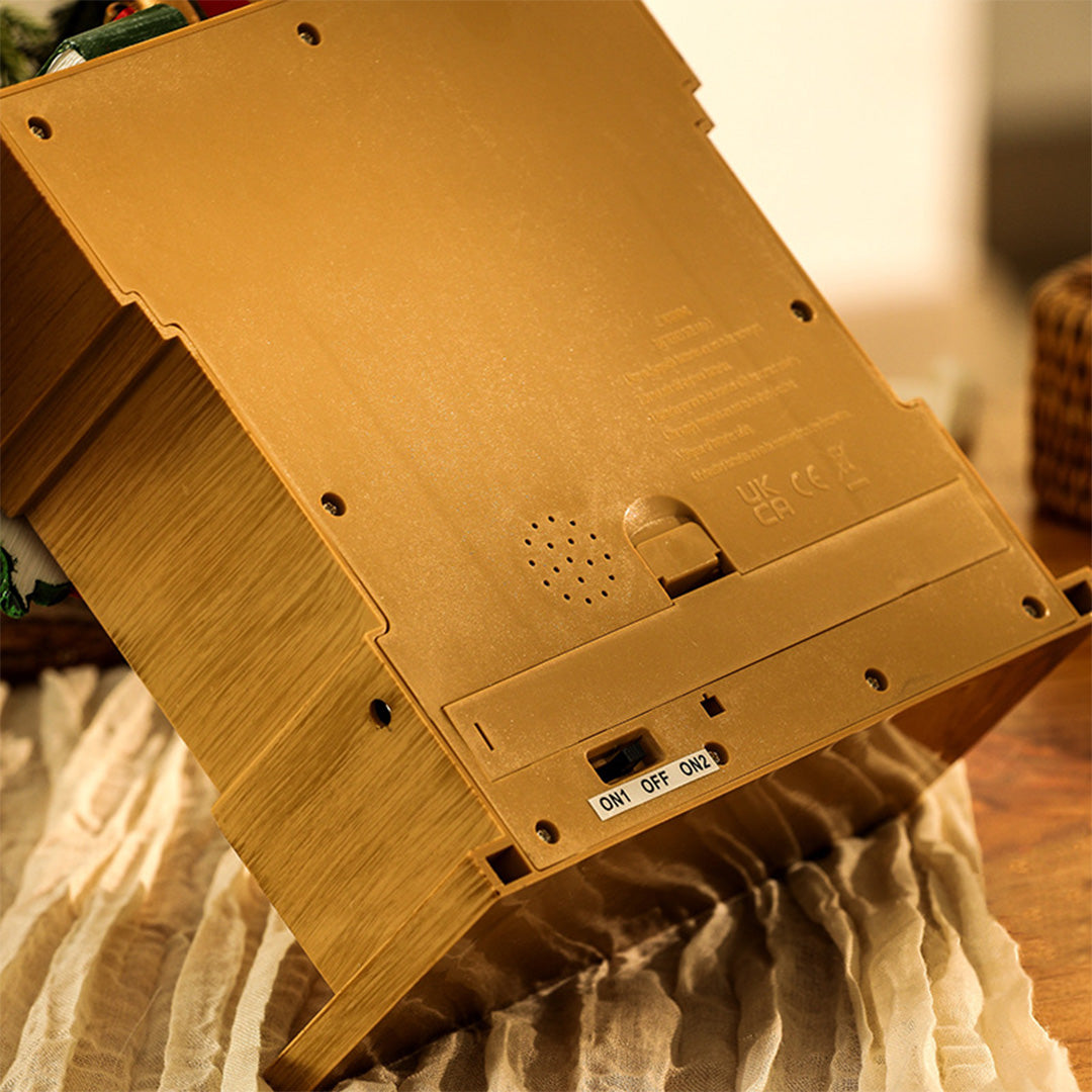 light up christmas ornament shaped like a fireplace with glowing interior and wreath décor