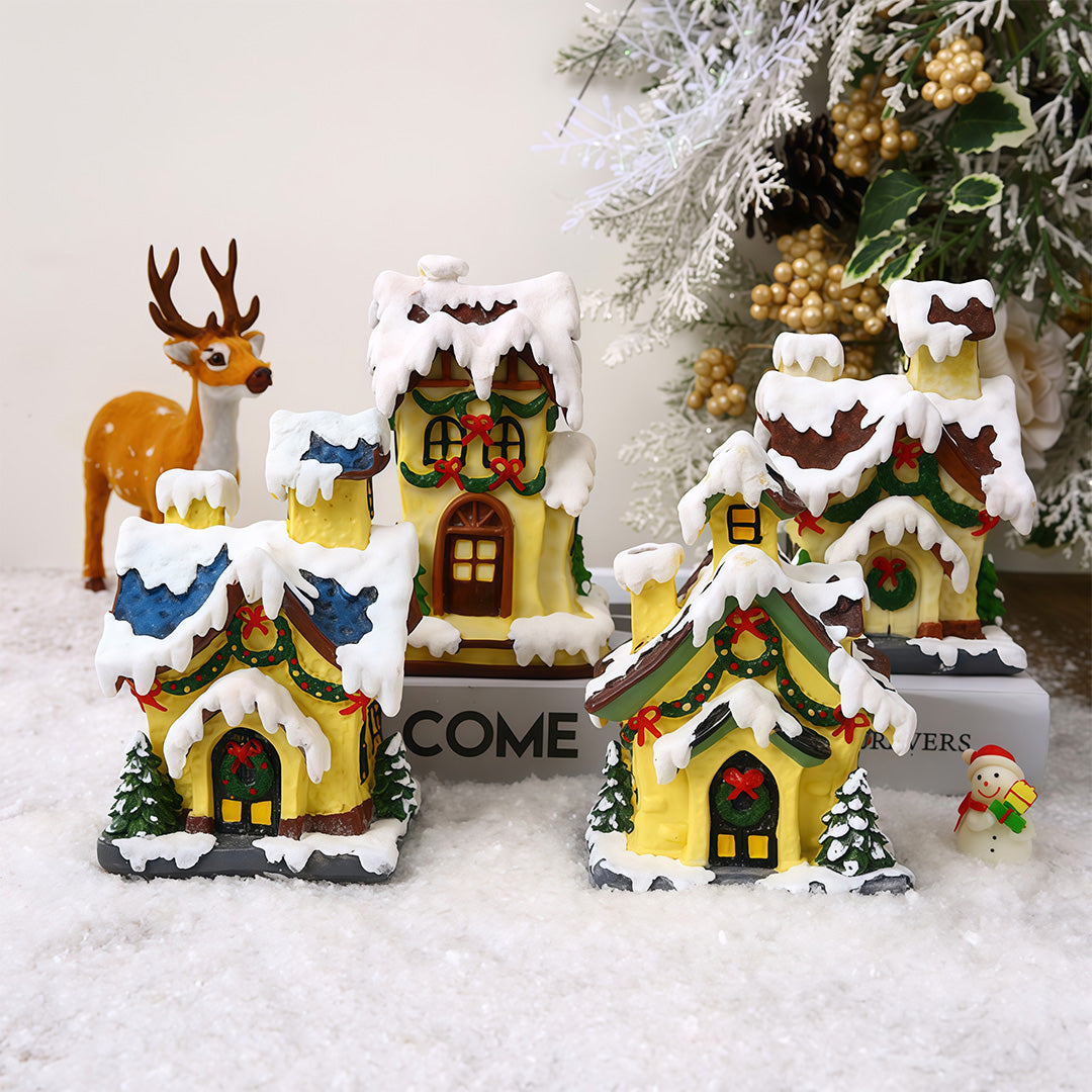 Lighted ceramic Christmas village house with snowy roof and warm yellow lighting.