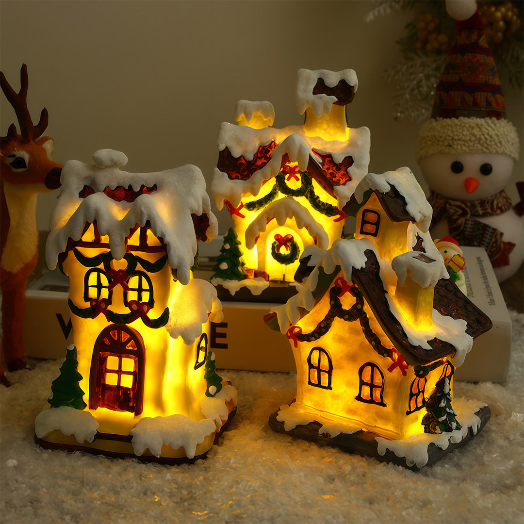 Lighted ceramic Christmas village house with snowy roof and warm yellow lighting.