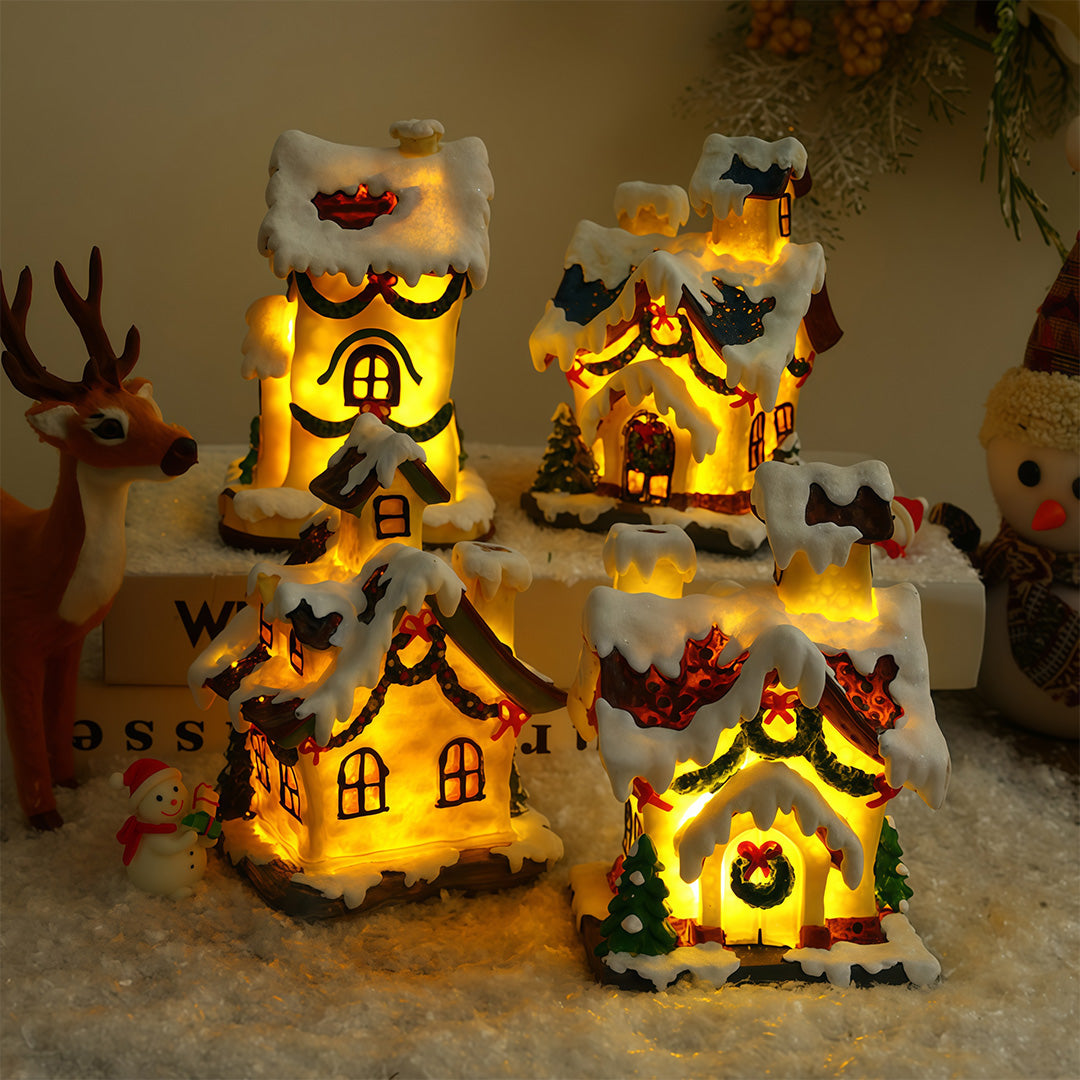 Lighted ceramic Christmas village house with snowy roof and warm yellow lighting.